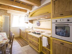 uma cozinha com um fogão e um micro-ondas em Belvilla by OYO Villa Vanessa Coccinella em Fano