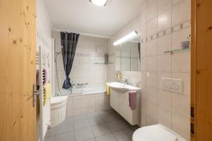 a bathroom with a toilet and a sink and a tub at Trü-Sura Nr. 7 in Scuol +7 photos