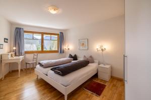 a bedroom with a bed and a desk and a window at Trü-Sura Nr. 7 in Scuol
