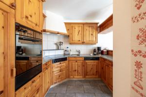 a kitchen with wooden cabinets and a sink at Trü-Sura Nr. 7 in Scuol +7 photos
