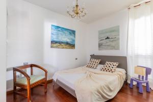 佐拉普雷多薩的住宿－Zola Predosa Apartment by Wonderful Italy，一间卧室配有一张床、一把椅子和一个吊灯。