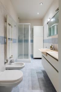 Baño blanco con 2 lavabos y aseo en Zola Predosa Apartment by Wonderful Italy, en Zola Predosa