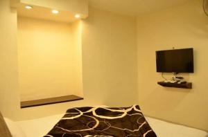 a room with a television and a bed with a blanket at Hotel Bindra Paradise 800 Meter From Golden Temple in Amritsar