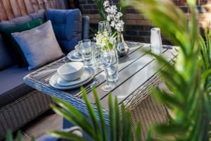 a table with plates and glasses on a patio at Offers Families Contractors Business Sleeps 9 in Hillingdon