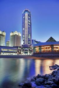 un profilo della città con edifici alti e l'acqua di Hilton Doha a Doha