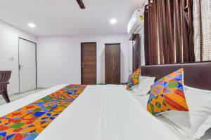 a bedroom with a large bed with a colorful blanket at FabHotel Vishwa Palace in Ahmedabad