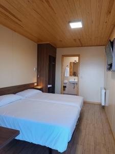 1 dormitorio con 1 cama blanca grande y baño en Motel 112, en Algora