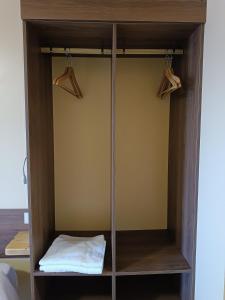 a wooden cabinet with two hangers on top of it at Motel 112 in Algora