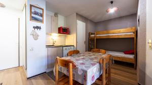 モリヨンにあるGrande Neige 23 - Appt pied des pistes 4 persのテーブルと二段ベッド付きの小さな部屋です。