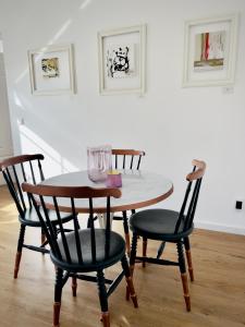 einem Holztisch mit vier Stühlen und einem Tisch mit Brille darauf in der Unterkunft Gallery Apartment Bielefeld in Bielefeld