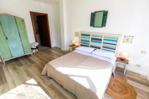 een slaapkamer met een bed, 2 tafels en een spiegel bij A casa di Vale in Lodi