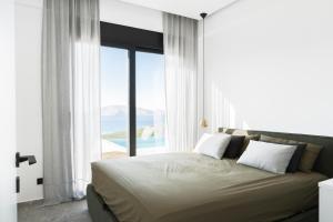 a bedroom with a bed with a view of the ocean at KATHOS RESIDENCE in Kavoúsion