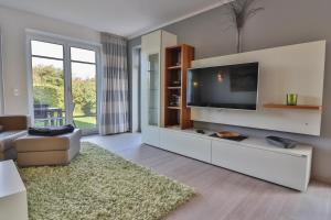 een woonkamer met een grote flatscreen-tv bij Düünleev in Langeoog