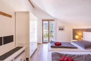 1 dormitorio con 2 camas y ventana grande en Pütvia 245F en Scuol