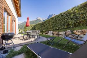 a backyard with a grill and a table and chairs at Pütvia 245F in Scuol