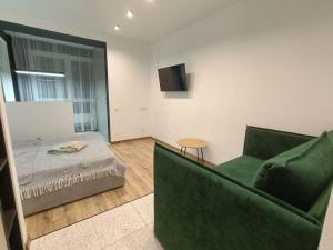 ein Wohnzimmer mit einem grünen Sofa und einem Bett in der Unterkunft ЖК Аржанова (Arjanova) in Dnipro