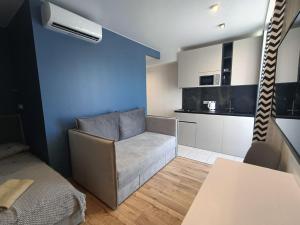ein Wohnzimmer mit Couch und Küche in der Unterkunft ЖК Аржанова (Arjanova) in Dnipro