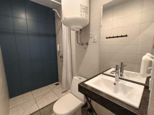 La salle de bains est pourvue de toilettes blanches et d'un lavabo. dans l'établissement ЖК Аржанова (Arjanova), à Dnipro