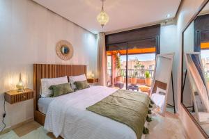 a bedroom with a large bed and a balcony at L'Atlas - Appartement Authentique à Gueliz in Marrakesh +11 photos