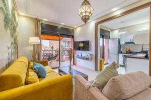 a living room with a yellow couch and a kitchen at L'Atlas - Appartement Authentique à Gueliz in Marrakesh