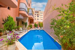 a swimming pool in the courtyard of a building at L'Atlas - Appartement Authentique à Gueliz in Marrakesh