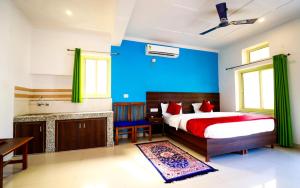 a bedroom with a bed and a blue wall at Manzil Hostel in Rishīkesh