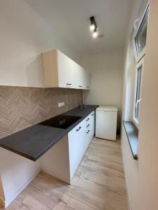 a kitchen with white cabinets and a black counter top at Studio Bielawa u podnóża Gór Sowich in Bielawa