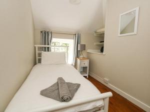 a bedroom with a white bed with a towel on it at Wayside in Beaminster
