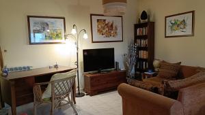 a living room with a couch and a television at Casa con Giardino in Milazzo