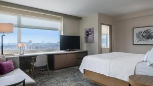 a bedroom with a bed and a desk with a television at The Westin Chicago Lombard in Lombard