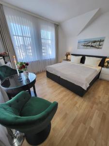 um quarto com uma cama, uma cadeira e uma mesa em Villa Wally em Westerland