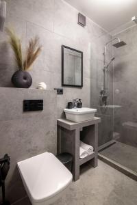 a bathroom with a sink and a shower and a toilet at Romari Vip Дорошенка 13 in Lviv