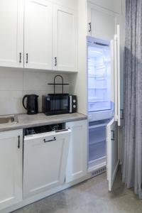 a kitchen with white cabinets and a refrigerator at Romari Vip Дорошенка 13 in Lviv