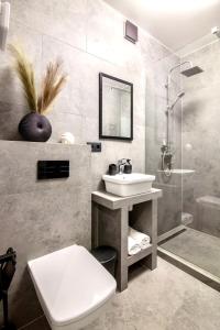 a bathroom with a sink and a toilet and a shower at Romari Vip Дорошенка 13 in Lviv