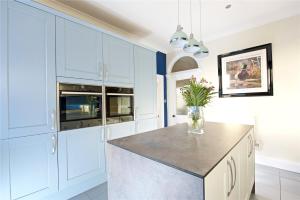 a kitchen with white cabinets and a vase of flowers at Equestrian Idyllic Victorian Retreat 