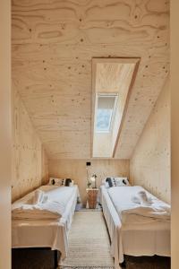two beds in a room with wooden ceilings at Lodgen Stryn in Stryn