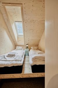 two beds in a tiny house with a window at Lodgen Stryn in Stryn