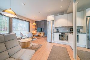 Levillas Platinum 2B2 في ليفي: غرفة معيشة مع أريكة ومطبخ