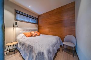 1 dormitorio con 1 cama y pared de madera en Levillas Platinum 2B2 en Levi