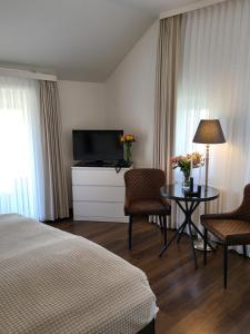 a hotel room with a bed and a table and a television at Villa Wally in Westerland (Sylt)