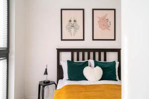 sypialnia z łóżkiem z zielonymi poduszkami i poduszką sercową w obiekcie Royal Wilanów Comfort Apartment w Warszawie