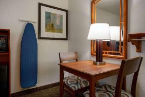 Habitación con escritorio y tabla de surf en la pared. en Days Inn by Wyndham Encinitas Moonlight Beach, en Encinitas