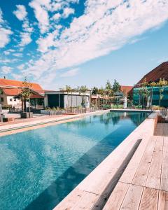 a swimming pool at a resort with a blue sky at Gut Hügle Erlebnishof & Spa in Ravensburg