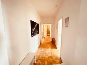 un pasillo con paredes blancas y suelo de madera en Cozy Apartment close to Hamburg, en Reinbek