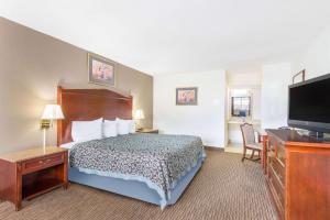 a hotel room with a bed and a flat screen tv at Days Inn by Wyndham Arlington Pentagon in Arlington