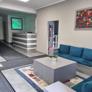 a living room with a blue couch and a table at Glass Cube Hotel in Chişinău