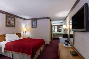 a hotel room with a bed and a flat screen tv at Howard Johnson by Wyndham Salem Hotel & Conference Center in Salem