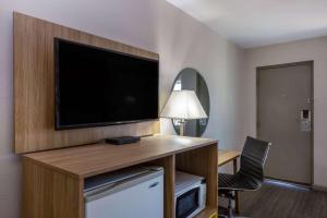 a hotel room with a flat screen tv on a wall at Days Inn by Wyndham Roswell in Roswell