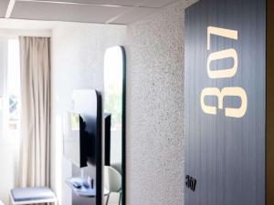 a mirror in a hotel room with a reflection of a mirror at ibis Beziers Est Mediterranee A9/A75 in Béziers