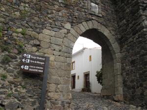 an archway in a stone wall with a sign at Casa do Castelo - Coroa in Castelo de Vide